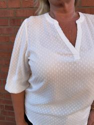 Vit blus med strukturprickar
