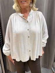 Cremevit blus med guldknappar
