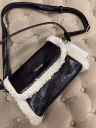 Svart väska med fuskpälsdetaljer och axelrem