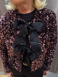 Rosa paljettjacka med rosetter