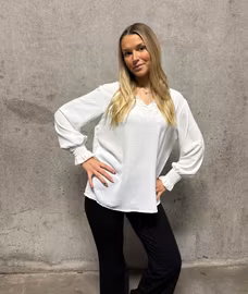 Vit blus med v-ringning och volang