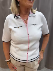 Vit piké med rosa och svarta detaljer