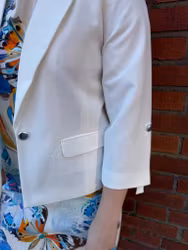 Cremevit kavaj med slejf på ärmen