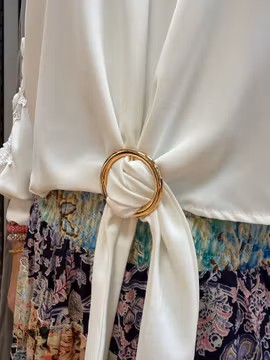 Vit blus med spets och guldspänne