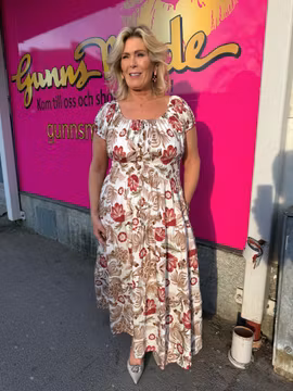 Cremevit maxiklänning med röda/bruna blommor
