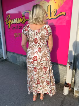Cremevit maxiklänning med röda/bruna blommor