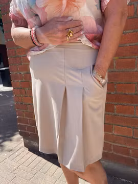 Kort beige kjol med lagda veck