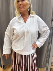 Vit blus med krage och knappdetaljer