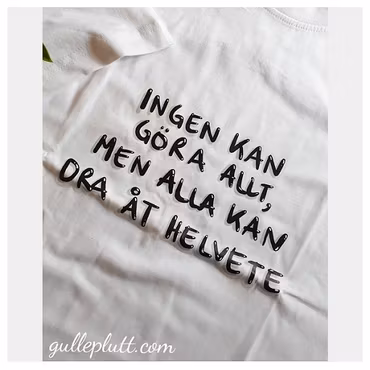 Vit T-shirt, med citatet "Ingen kan göra allt, men alla kan dra åt helvete"