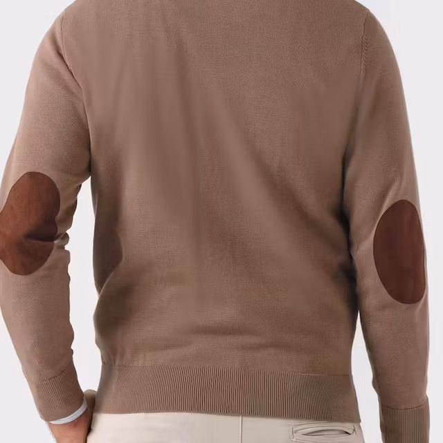 Person bär beige tröja med armbågslappar i mockaimitation.
