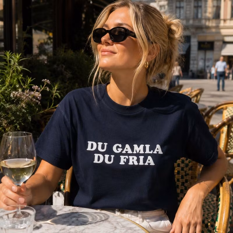 Mörkblå t-shirt med vit bokstavstext.
