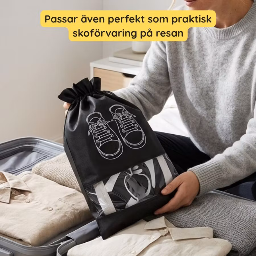 Svart skopåse med skomotiv i en öppen resväska