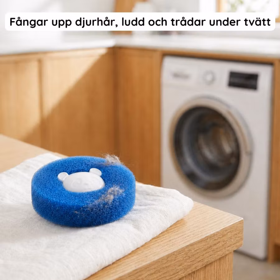 Blå tvättboll med uppsamlat hår och ludd på en handduk vid tvättmaskinen