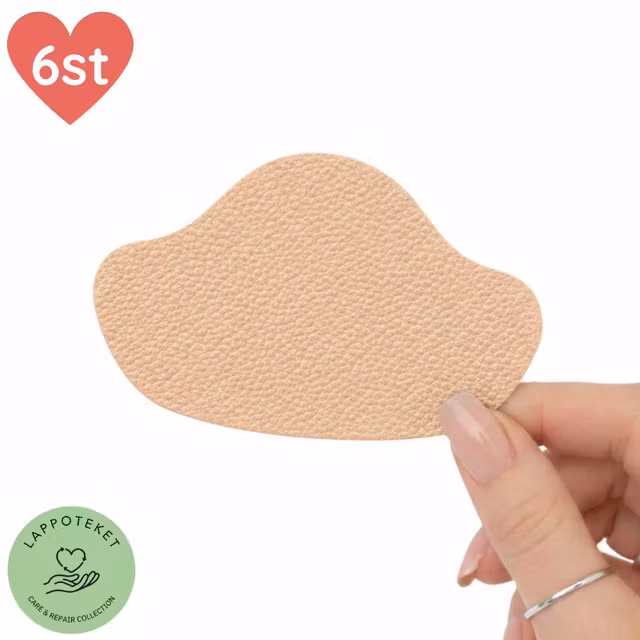 Beige självhäftande lagningslapp för hälkappa, hålls i hand.