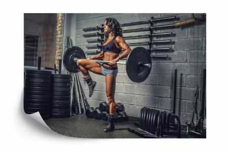 Fototapet - Athletic woman lifting a barbell