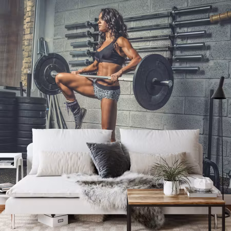 Fototapet - Athletic woman lifting a barbell