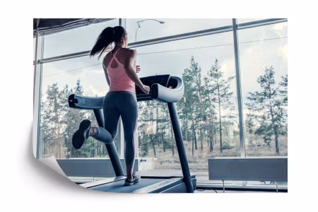 Fototapet - Woman on a treadmill with the