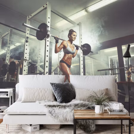 Fototapet - Woman at the gym lifting a barbell