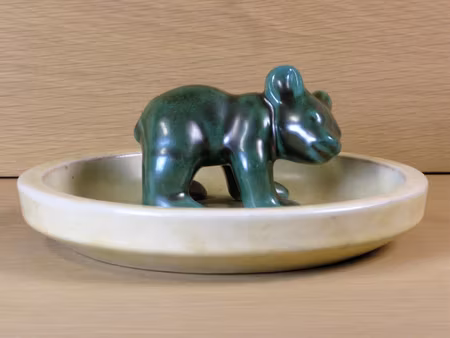 Green bear standing on dish
