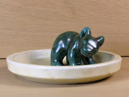 Green bear standing on dish