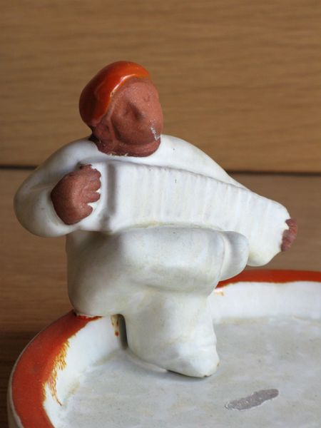 grey/orange accordion man in ashtray 3118