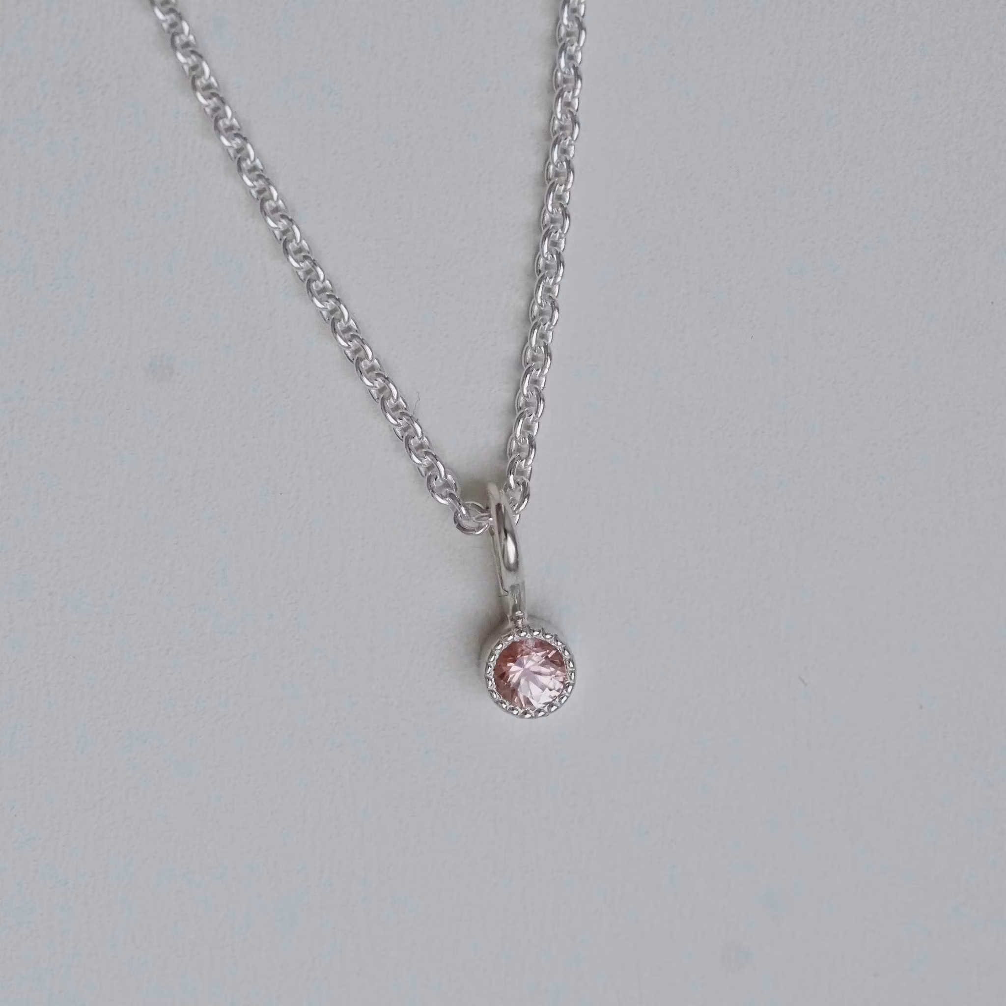 "Twinkle" pendant in silver with a peachpink sapphire