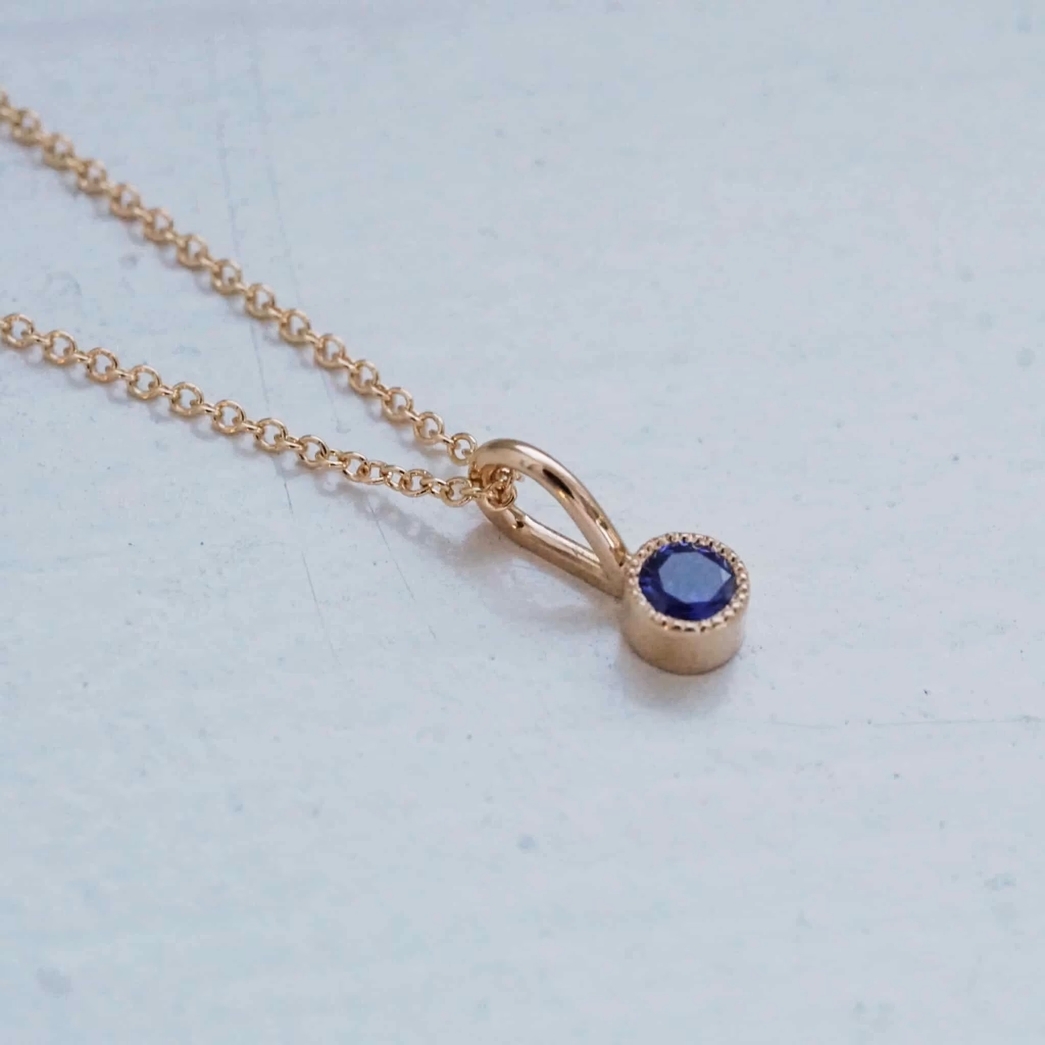 "Twinkle" pendant in gold with a sapphire