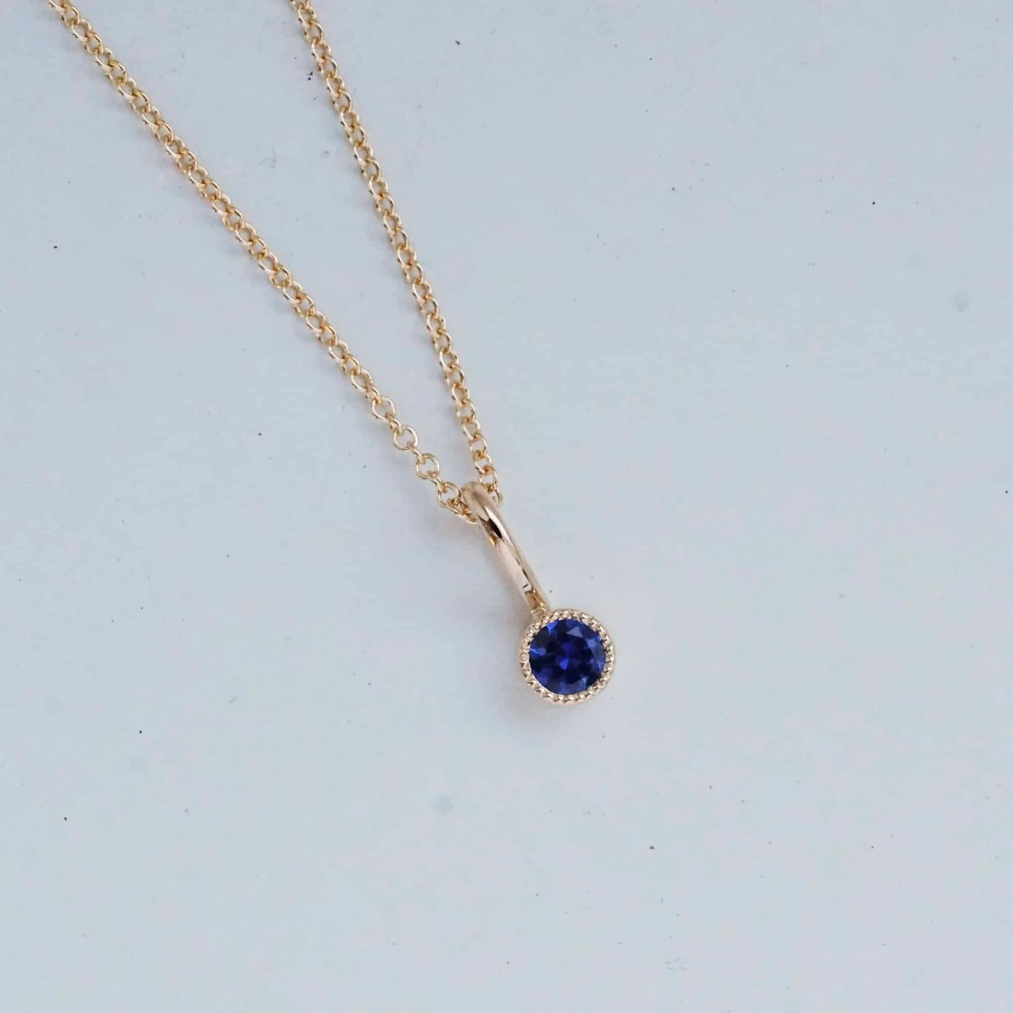 "Twinkle" pendant in gold with a sapphire