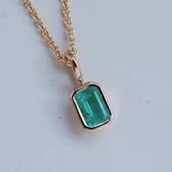 Pendant in gold with an emerald
