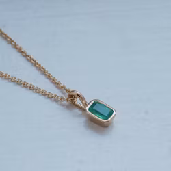 Pendant in gold with an emerald