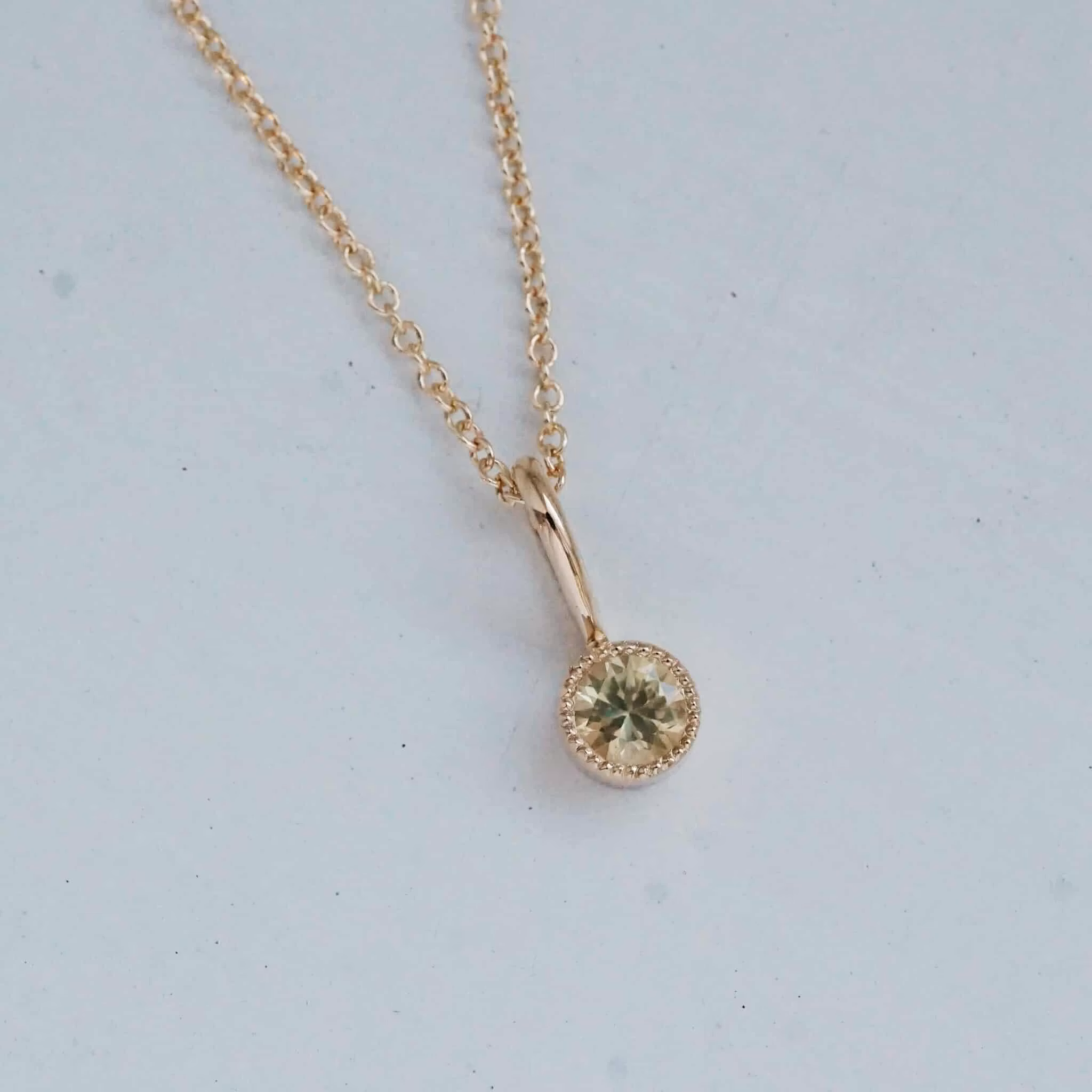 "Twinkle" pendant in gold with a light yellow sapphire