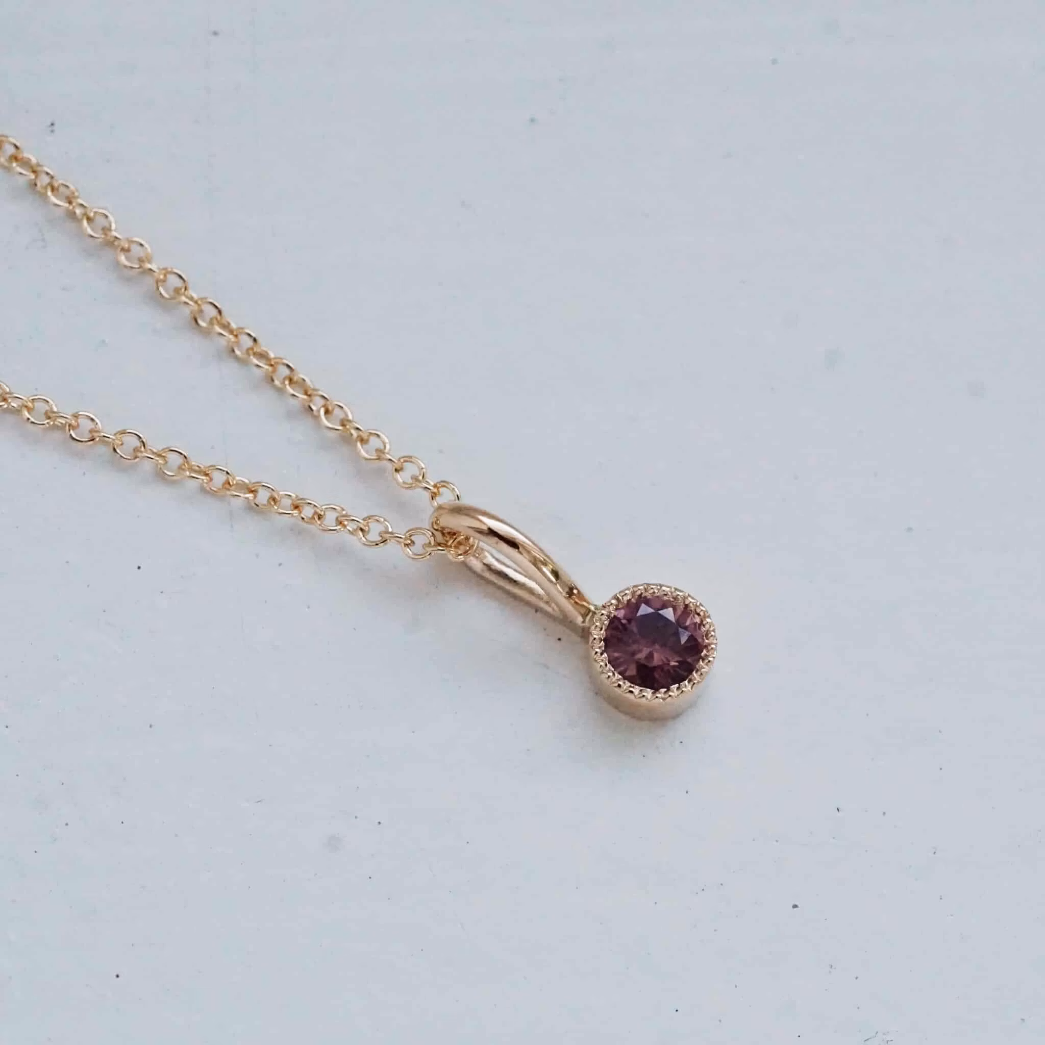 "Twinkle" pendant in gold with a purple-red sapphire
