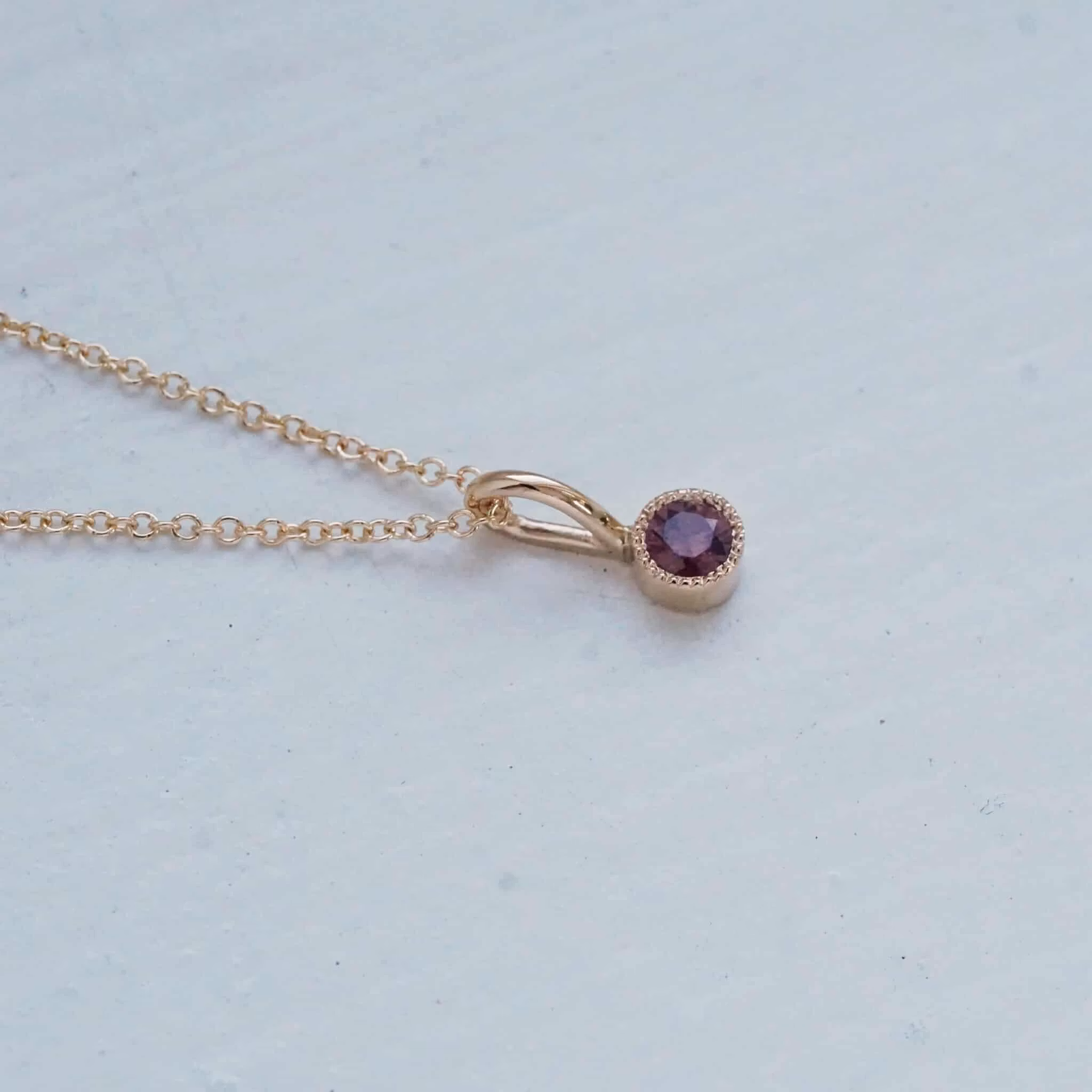 "Twinkle" pendant in gold with a purple-red sapphire