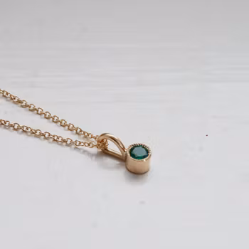 "Twinkle" pendant in gold with an emerald