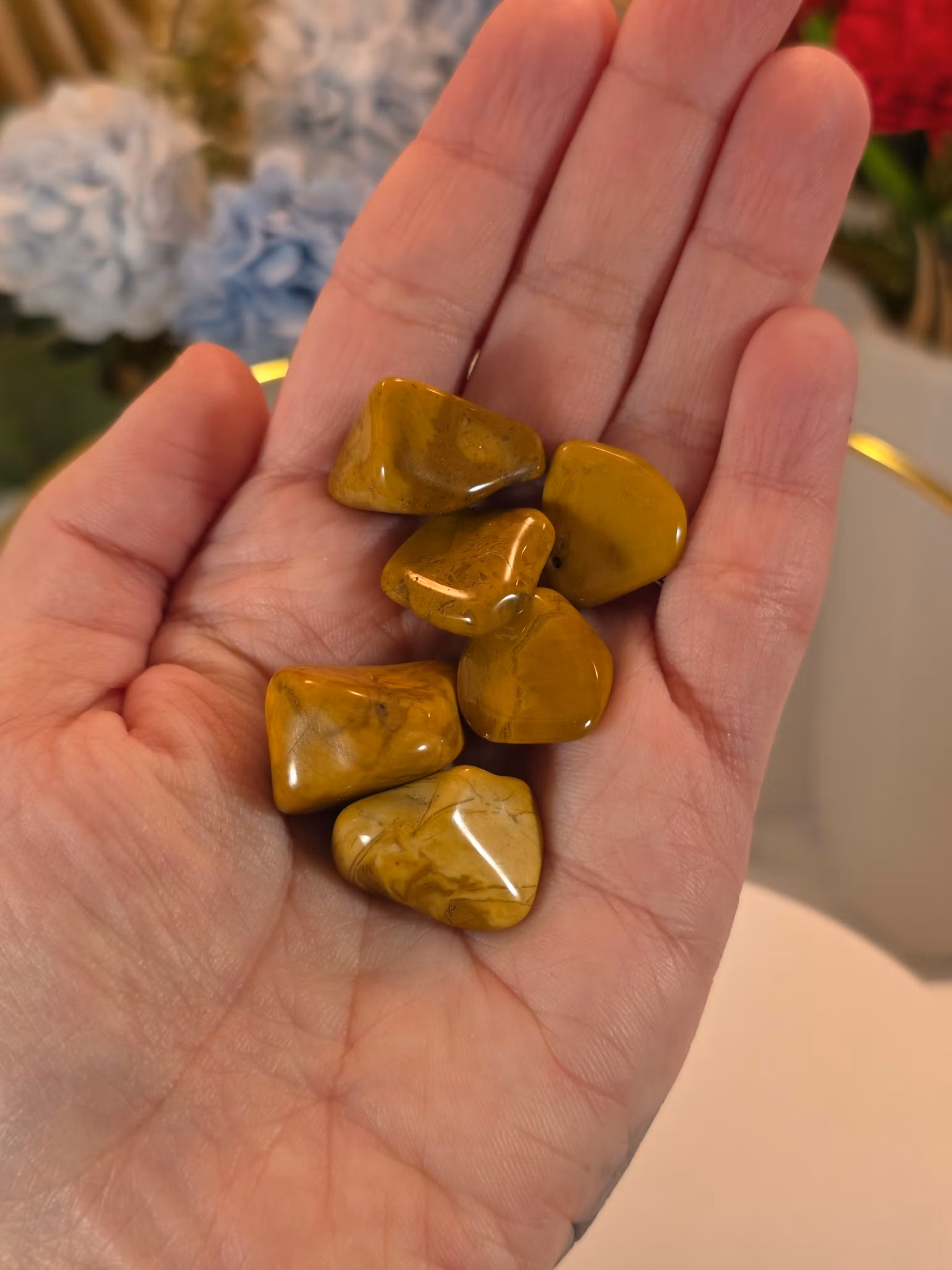 Gul jaspis trumlad, cirka 2–2,5 cm, med rundad form och naturliga färgvariationer