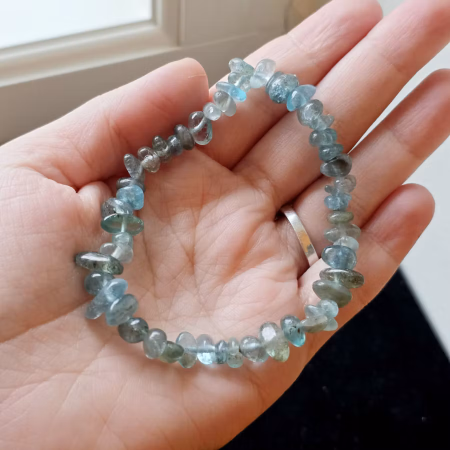 Ett vackert och naturligt armband med ljusblå klar apatit i oregelbundna chipstenar, trädda på ett elastiskt band som gör det enkelt att bära och passar de flesta handleder