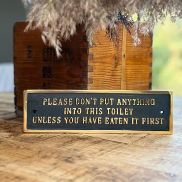 Tjock metallskylt med text ”toilet..."