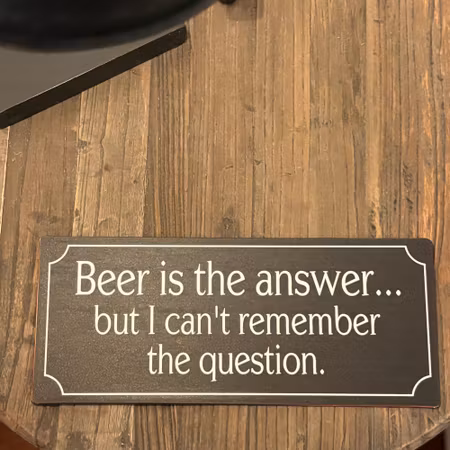 Metallskylt med text ”Beer is the answer..."